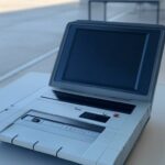 Urna eletrônica em seção eleitoral vazia no DF, simbolizando regularização de título para eleições de 2026.