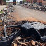 Rua em Ceilândia com força-tarefa removendo entulhos e carcaças de veículos abandonados.