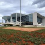 Edifício judicial em Brasília com bandeira a meio mastro, simbolizando falecimento de desembargador no Distrito Federal.