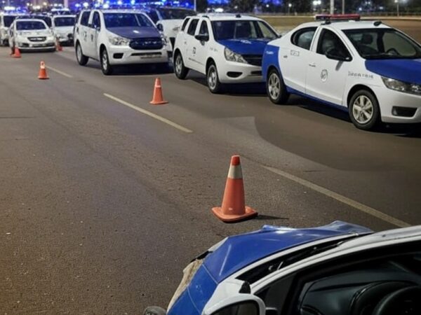 Viaturas do Detran-DF em blitz surpresa em Brasília, com uma colidida, cones de sinalização e avenida noturna.