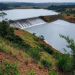 Reservatório do Descoberto transbordando no DF, com risco de inundações em áreas de cerrado.