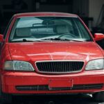 Carro danificado em oficina mecânica no Brasil, representando demora em conserto e condenação judicial.