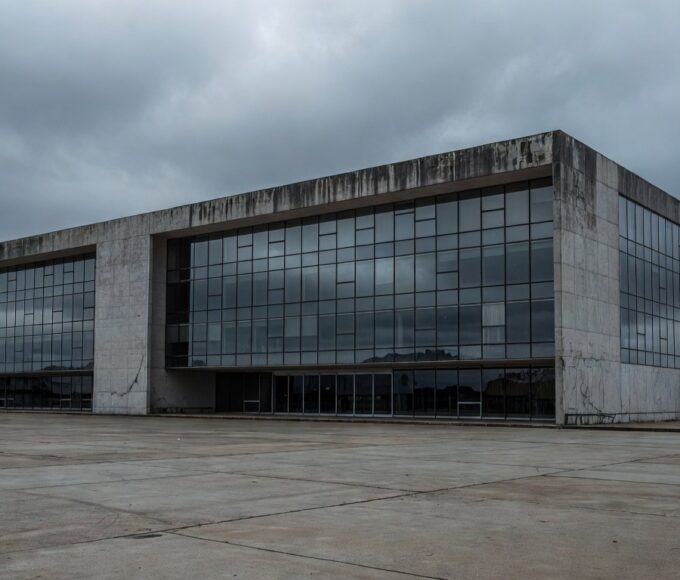 Prédio governamental abandonado em Brasília representando falhas na proteção a mulheres e idosos no DF.