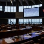 Fachada da CLDF com telas transmitindo sessão ao vivo, sob críticas por opacidade no Legislativo.