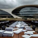 Edifício governamental em Brasília com documentos acumulados, representando atraso na regulamentação de lei contra supremacismo no DF.