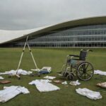 Fachada da CLDF em Brasília com símbolos de enfermagem sob céu nublado, ilustrando 45 anos de sindicato em crises não resolvidas.