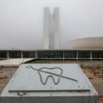 Edifício da CLDF em Brasília com placa simbólica de 60 anos do CRO-DF, sob céu nublado, destacando frustrações e demandas ignoradas.