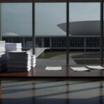 Mesa com formulários de inscrição para estágios na Caesb em Brasília, simbolizando vagas limitadas e crise de desemprego jovem.