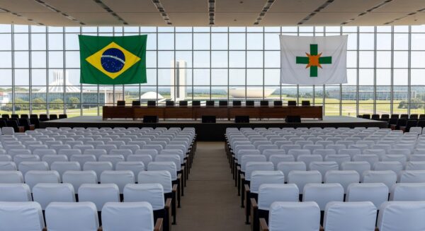 Auditório em Brasília preparado para cerimônia de formatura do Programa Qualifica DF, com bandeiras e decoração.