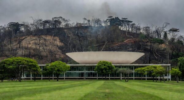Edifício da CLDF em Brasília com mata degradada ao fundo, representando homenagem a agentes ambientais e críticas por ineficácia na vigilância.