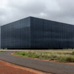 Sede da Caesb em Brasília com bandeiras a meio mastro, representando luto pela morte repentina de advogado.