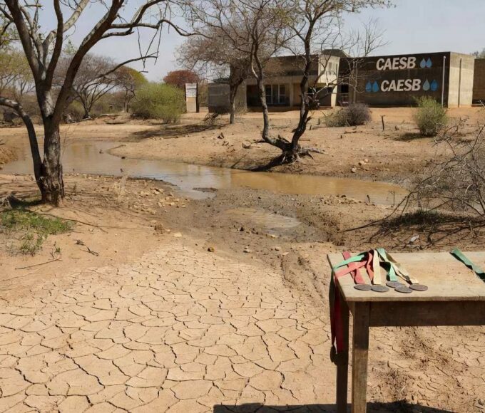 Paisagem do Cerrado com nascente seca e estrutura da Caesb, destacando perda de 50% das nascentes no Dia Mundial da Água.