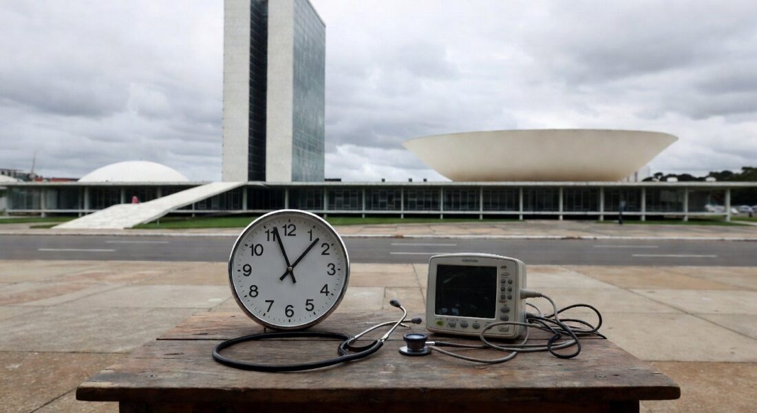Edifício governamental em Brasília com relógio parado e equipamentos médicos, simbolizando falhas em diagnósticos de cardiopatias para bebês com Down.