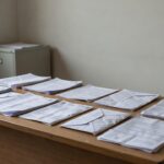 Contas de serviços públicos sobre mesa com Congresso Nacional ao fundo em Brasília